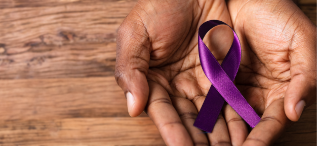 hand holding purple alzheimer ribbon
