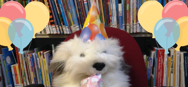 photo of a stuffed toy dog wearing a birthday hat