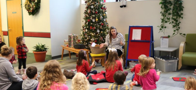 photo of adult reading to children in a holiday setting